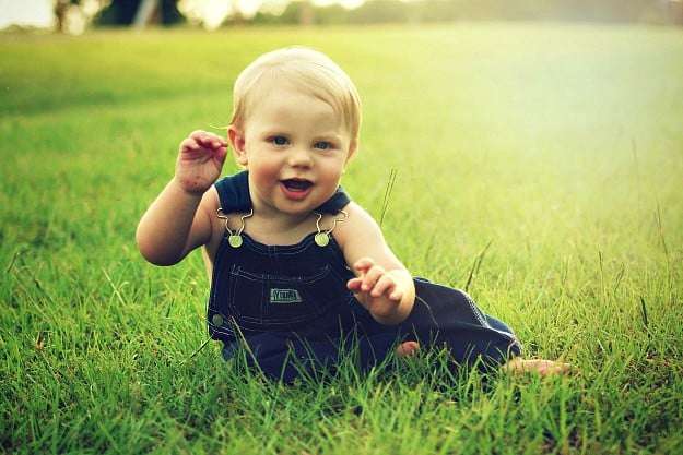 toddler playing on the grass | When Do Babies Start Talking? Looking Forward To Key Milestones | when do kids start talking