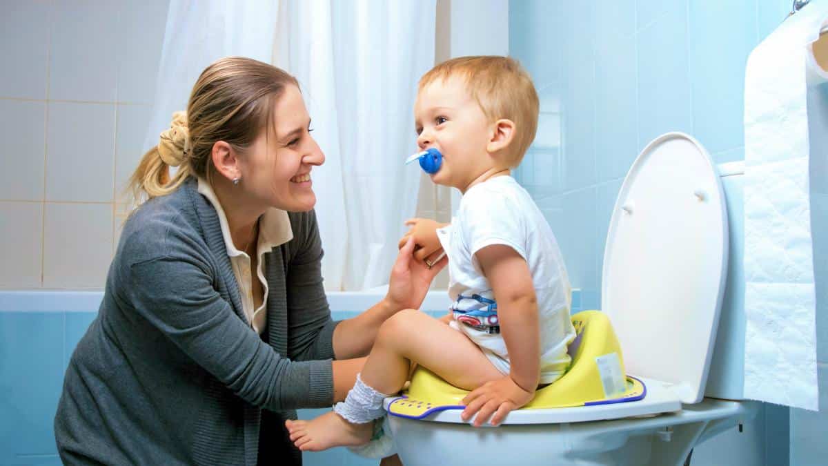 Toddler Sitting on A Potty with his Mom | A Step-By-Step Guide To Potty Training Your Little One | potty training tips